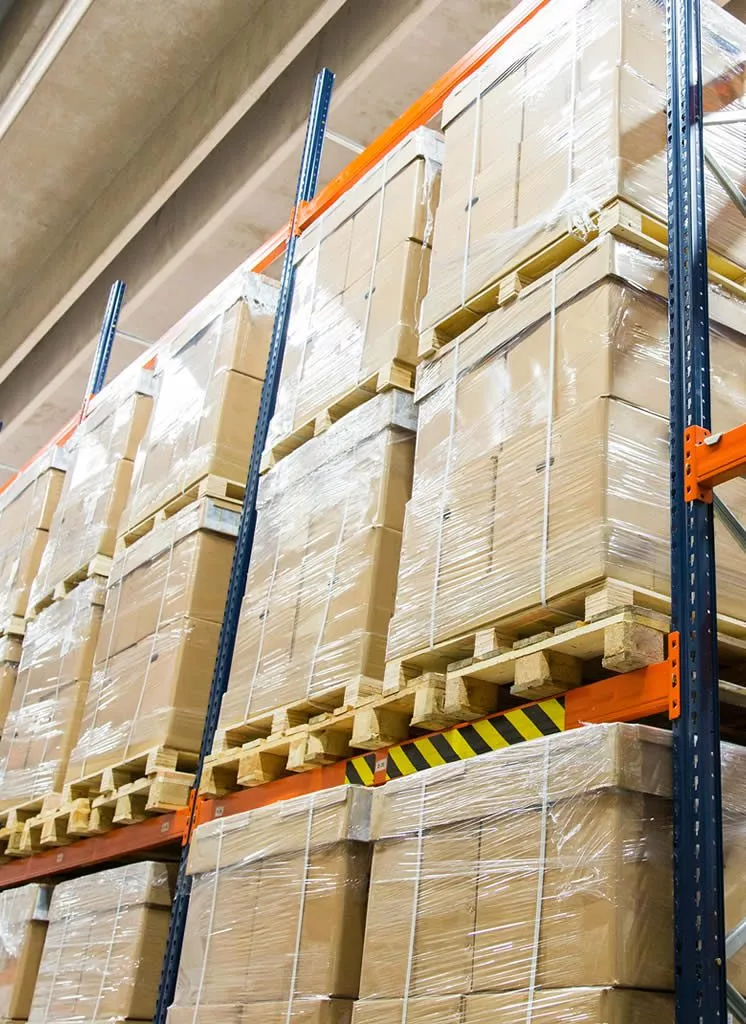 palettes de marchandises en surproductions stockées dans des cartons sur des étagères d'entrepôt de destockage