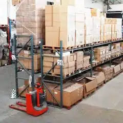palettes de marchandises et cartons de produits dans un grand entrepôt de destockage